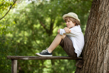 Boy sits on a bench.