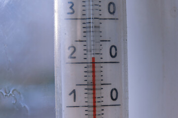 Macro shot of an outdoor thermometer, where the red column shows exactly 21 degrees. Concept of comfortable temperature, measurements, summer weather, climate