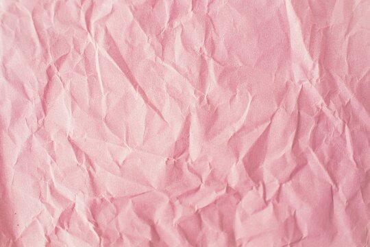 Pink crumpled paper background. Texture of crumpled paper, top view, copy space.