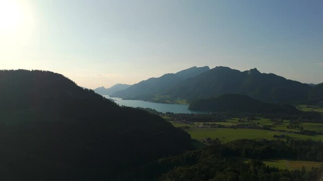 Lake Wolfgangsee, Strobl village and Salzburg Alps aerial drone view during golden hour, alpine valley and mountain silhouettes in Austria&rsquo;s lake.
