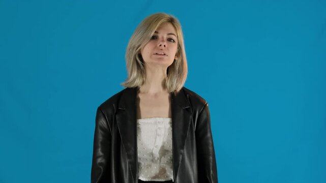 Angry young woman screams furiously waving arms. Blonde female in bad mood overcome with anger argues jumps up shaking head slow motion