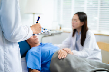 Doctor and nurse warmly support senior patient in hospital bed, discussing diagnosis & care plan.