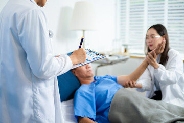 Doctor and nurse warmly support senior patient in hospital bed, discussing diagnosis & care plan.