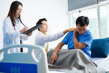 Obraz premium Doctor and nurse assess senior patient’s leg injury in hospital, using tablet x-ray to explain diagnosis and care.