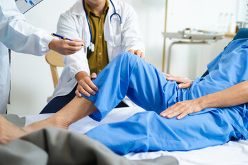 Doctors assess senior patient’s knee injury with care and teamwork in hospital.