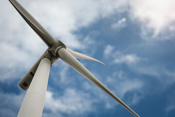 Close-up view of a wind turbine against a clear blue sky, representing innovation in renewable...