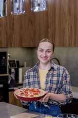 Smiling Woman in Kitchen Showing Freshly Baked Quiche Lorraine