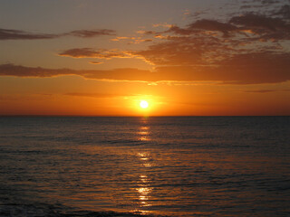 View of the sun rising over a calm sea. Summer sunrise.
