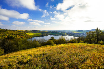 Landscape at the Schalkenmehrener Maar in autumn. View of the idyllic nature by the lake in the Eifel near the Dauner Maar.

