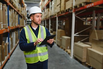 Portrait of warehouseman with clipboard checking delivery, stock in warehouse