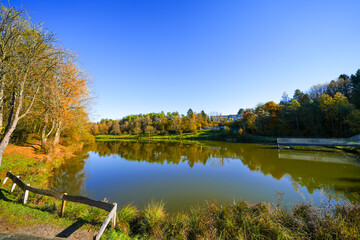 Landscape at the Gerolstein reservoir in autumn. Idyllic nature at the lake in the Eifel region.
