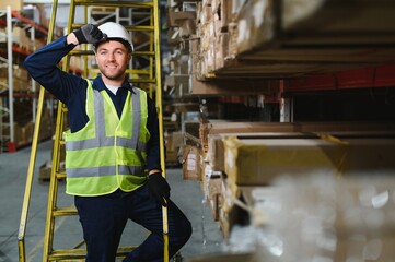 Portrait of a handsome warehouse worker in overalls and a helmet