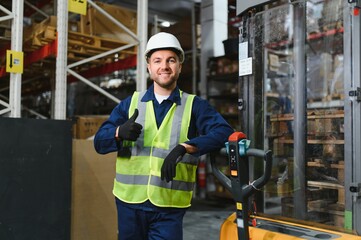 Portrait of a handsome warehouse worker in overalls and a helmet