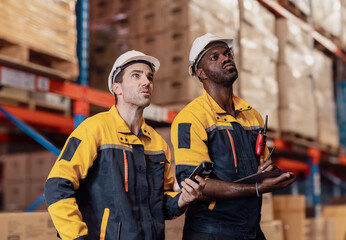 Warehouse manager, store inspector checking stock on storage shelf from inventory checklist. Two...