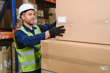 Portrait of a handsome warehouse worker in overalls and a helmet