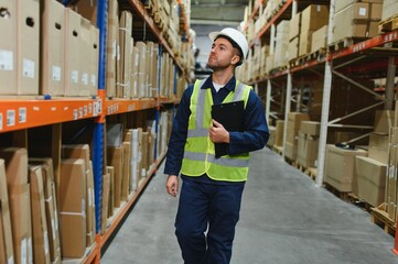 Portrait of a handsome warehouse worker in overalls and a helmet