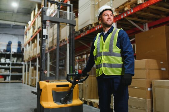 Portrait of a handsome warehouse worker in overalls and a helmet