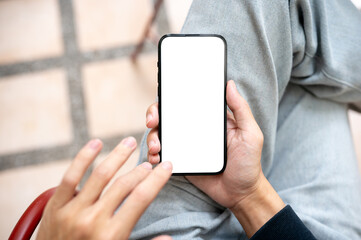 Hand holding and touching blank screen smartphone using application or social media as sits on bench