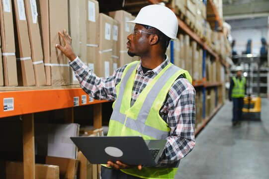 Portrait of a handsome african american warehouse worker in overalls and a helmet