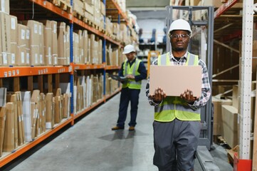 Portrait of a handsome african american warehouse worker in overalls and a helmet