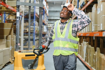 Portrait of a handsome african american warehouse worker in overalls and a helmet