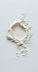 A circular hole is punched through a mound of white powder.  The powder has irregular edges and is scattered around the hole