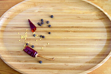 One broken pod of hot red pepper with seeds on wooden background, dried bitter chili pepper and...