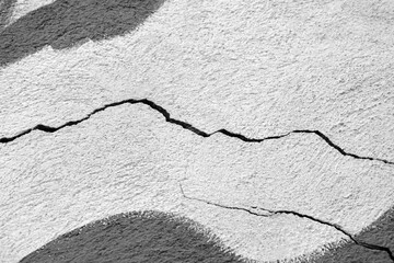 Two big winding descending crack on old colored plastering wall. Copy space. Selective focus.