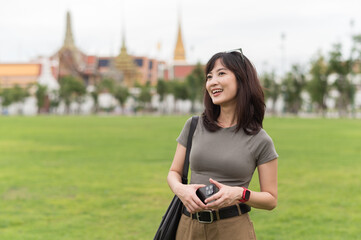 Happy solo Southeast Asian woman and teenager blogger enjoys world travel. tourism concept for...
