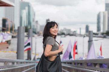 Young southeast asian woman teenager blogger using smartphone searching tourism guide. world travel...