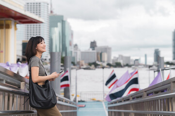 Young southeast asian woman teenager blogger explorer on world travel searching smartphone map...