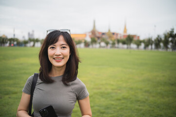 Happy solo southeast asian woman teenager blogger on world travel. An explorer enjoying local...