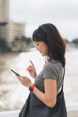 Young southeast asian woman teenager blogger explorer searching map smartphone for world travel guide. Tourism concept for local cultural experience asia by Chao Phraya River Bangkok Thailand