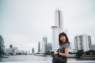 Solo world travel explorer. Happy young southeast asian woman and teenager blogger with smartphone. Asia tourism concept for local cultural experience on Chao Phraya river in Bangkok Thailand