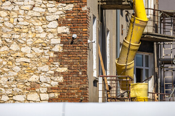 Yellow pipe for throwing rubble from a building, renovation of an old tenement house in the city...