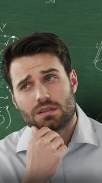 Man in front of moving maths on blackboard