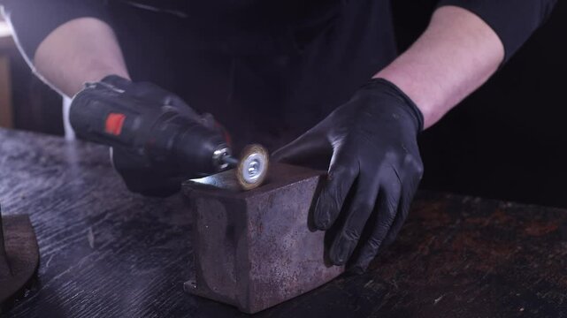 A closeup of a professional using a grinder on metal, showcasing exceptional craftsmanship in a workshop.