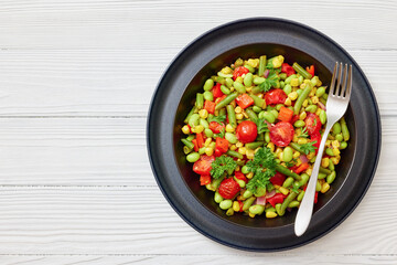 succotash of corn, beans, tomatoes, in black bowl
