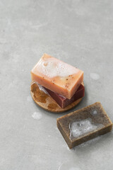Natural organic soap bars with white foam on a gray concrete background