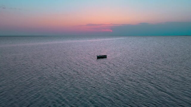 A boat sitting alone in the water at sunset. Location: Tunisia, Medenine , Zarzis.