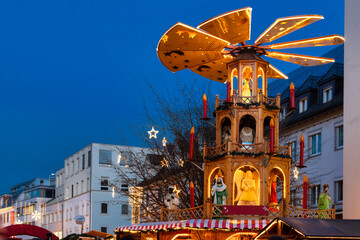 Traditional Christmas market with lights, wooden stalls and Christmas pyramid in downtown Bregenz,...
