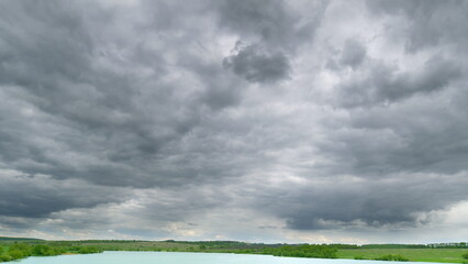 A Dramatic and Overcast Cloudy Sky Spreads Across a Calm and Tranquil Water Landscape During Dusk...