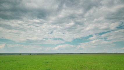 A Scenic Lush Green Field Set Against a Dynamic and EverChanging Cloudy Sky Above Time lapse.
