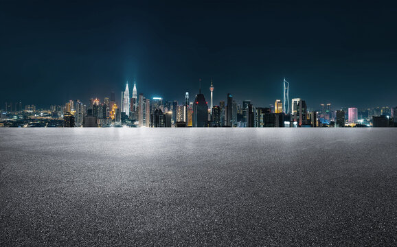 Night view of modern cityscape with empty asphalt road platform.