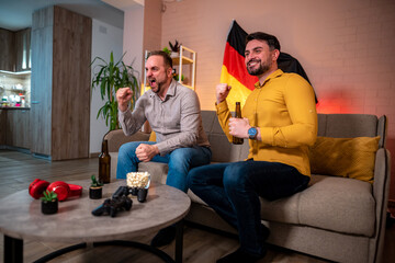 Friends celebrate a sports victory in a cozy living room