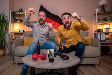 Enthusiastic friends celebrate a victory during a game night at home