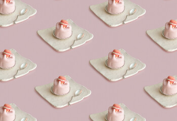Pattern of pink  cake with decor   lying on a triangular plate  with a decorative spoon on a pink...