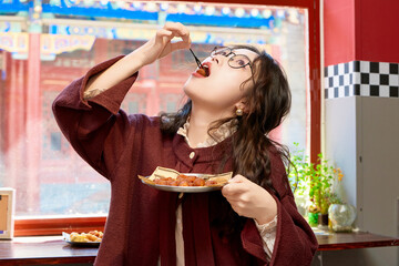 Oriental women eating a lot at the Meiyan hot dog fast food restaurant