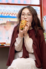 Oriental women eating a lot at the Meiyan hot dog fast food restaurant