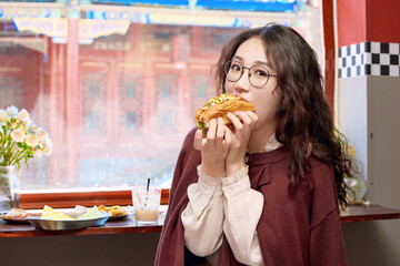 Oriental women eating a lot at the Meiyan hot dog fast food restaurant